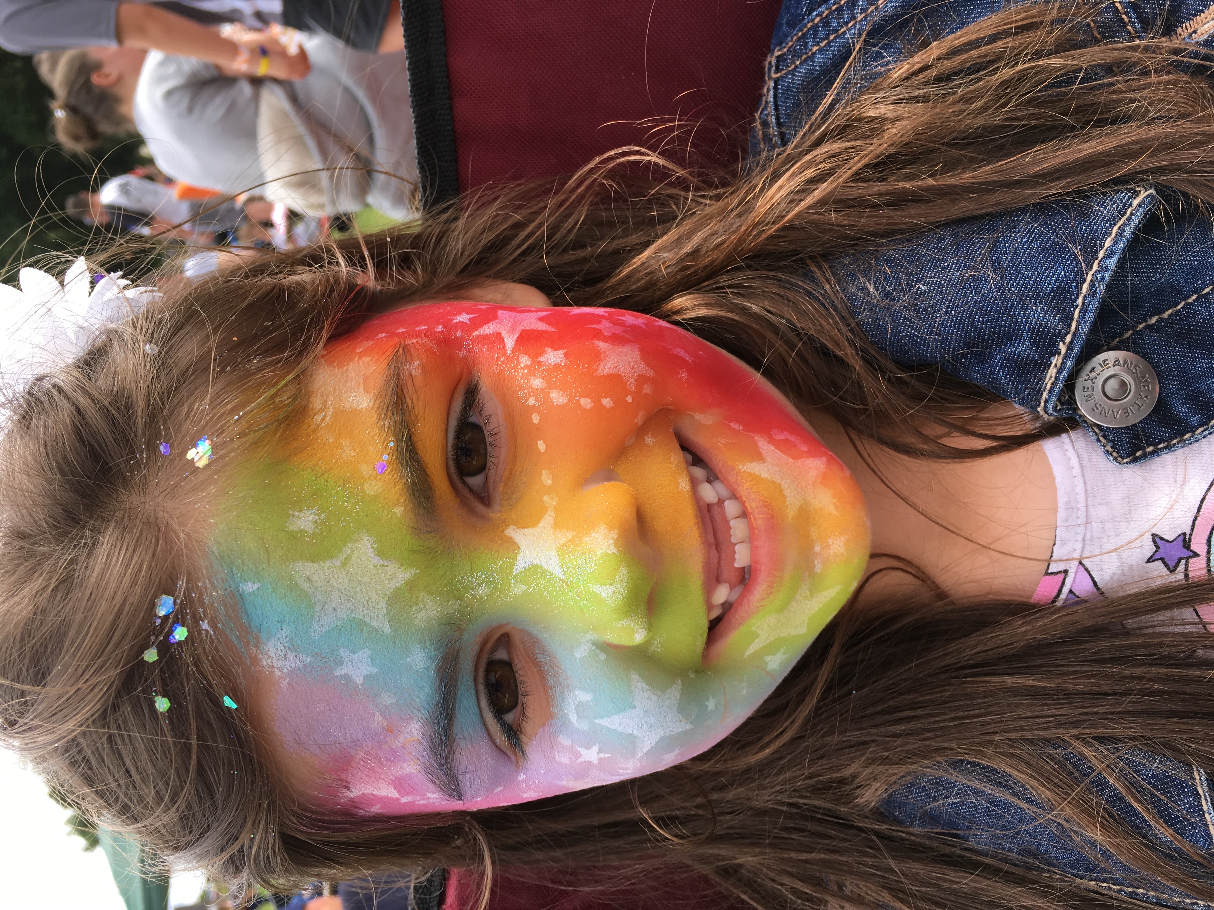 Little girl at Pride with rainbow facepaint