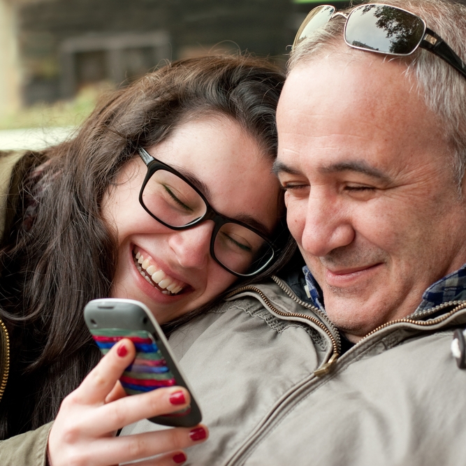 Father and teen daughter mobile phone